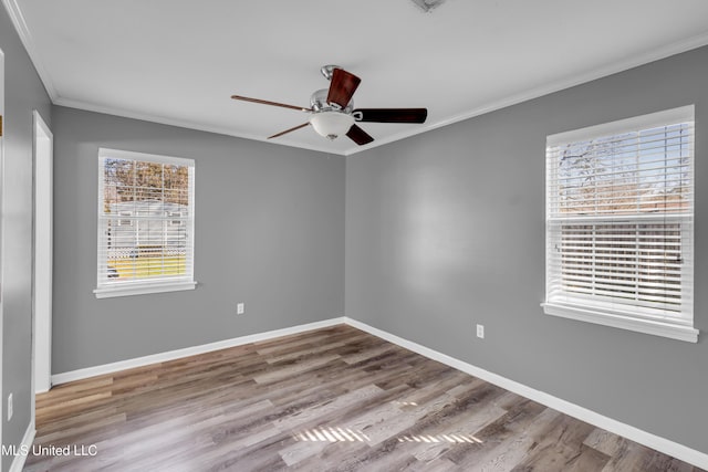 unfurnished room featuring baseboards, wood finished floors, a ceiling fan, and crown molding