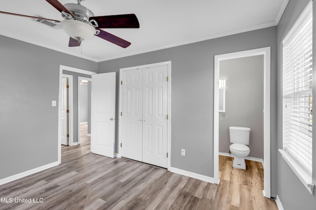 unfurnished bedroom featuring baseboards, visible vents, crown molding, and wood finished floors