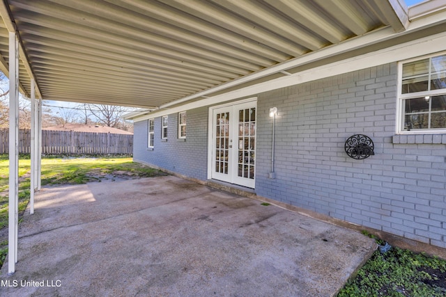 view of patio featuring fence, a carport, and french doors