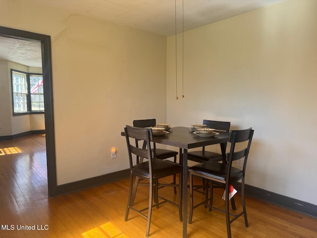 dining room with hardwood / wood-style flooring and baseboards