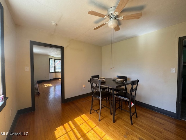 dining area featuring a ceiling fan, wood-type flooring, and baseboards