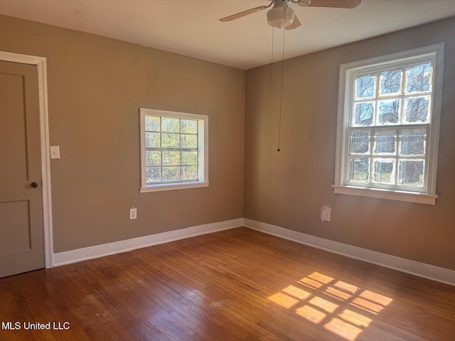 unfurnished room featuring plenty of natural light, baseboards, and hardwood / wood-style flooring