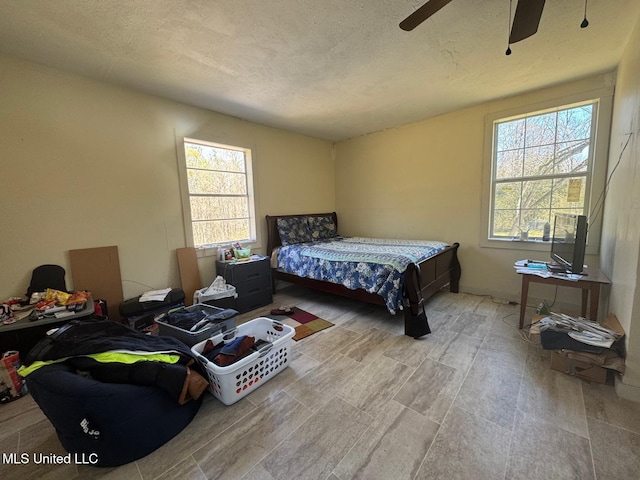 bedroom featuring ceiling fan and a textured ceiling