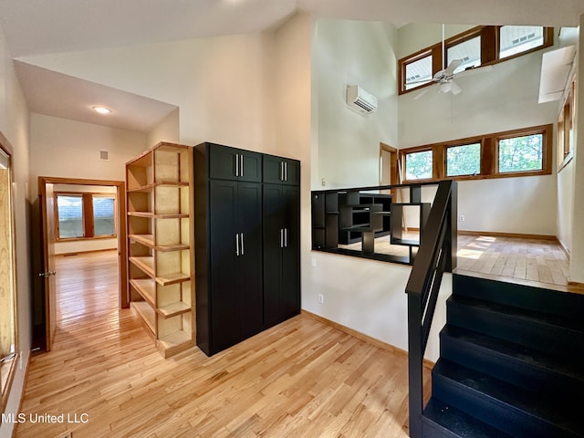 211 Monterey Dr, Clinton, MS 39056 - stairway with wood finished floors, ceiling fan, high vaulted ceiling, a wall mounted air conditioner, and baseboards