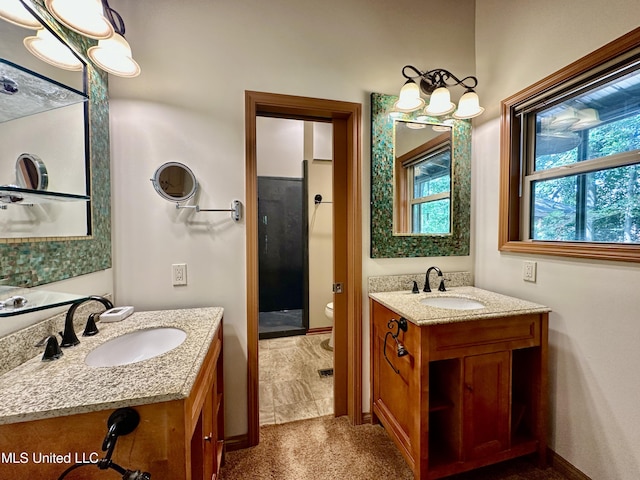 211 Monterey Dr, Clinton, MS 39056 - bathroom featuring two vanities, toilet, a stall shower, and baseboards