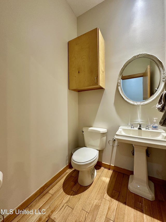 211 Monterey Dr, Clinton, MS 39056 - half bathroom featuring wood finished floors, toilet, and baseboards