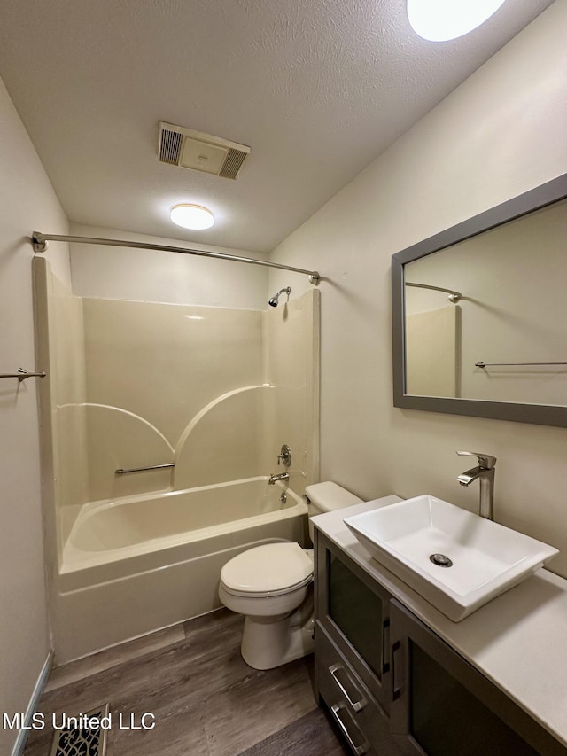 211 Monterey Dr, Clinton, MS 39056 - full bath with shower / tub combination, wood finished floors, vanity, toilet, and a textured ceiling