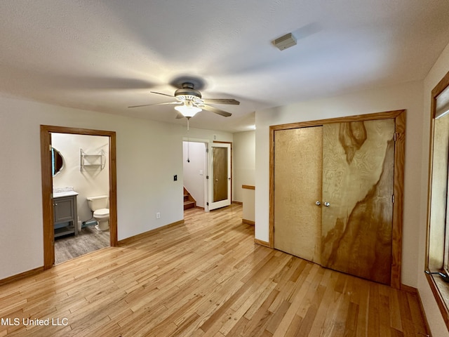 211 Monterey Dr, Clinton, MS 39056 - unfurnished bedroom with light wood-type flooring, baseboards, ensuite bath, and a ceiling fan