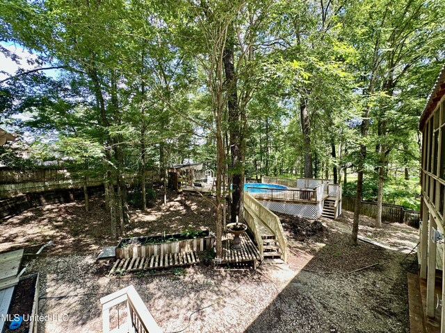 211 Monterey Dr, Clinton, MS 39056 - fenced backyard featuring a wooden deck and an outdoor pool