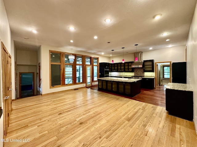 211 Monterey Dr, Clinton, MS 39056 - kitchen featuring wall chimney exhaust hood, black appliances, a spacious island, light wood-type flooring, and recessed lighting