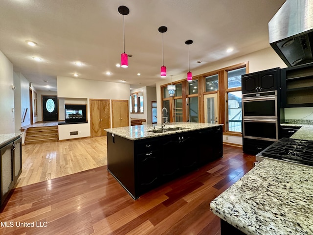 211 Monterey Dr, Clinton, MS 39056 - kitchen featuring a sink, wall chimney exhaust hood, dark wood-style flooring, dark cabinets, and recessed lighting