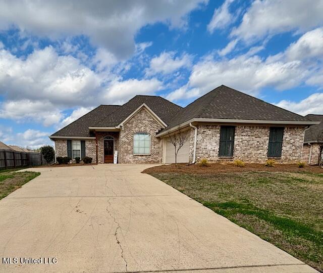 ranch-style home with a garage and a front yard