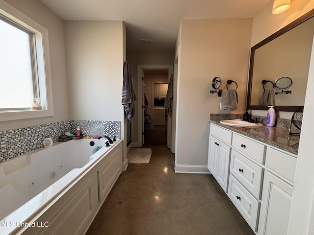 bathroom with vanity, concrete flooring, and a bath