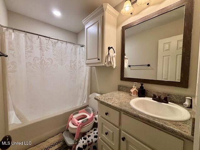 bathroom with shower / tub combo with curtain and vanity