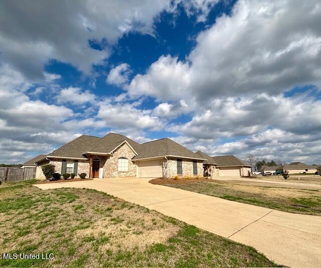 view of front of house featuring a garage and a front lawn