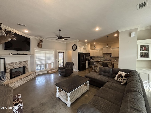 living room with crown molding, ceiling fan, and a fireplace