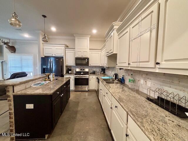 kitchen featuring light stone counters, sink, decorative light fixtures, and stainless steel appliances