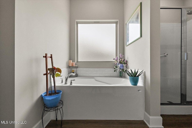 203 Vision Cv, Canton, MS 39046 - bathroom featuring a shower stall, a bath, and wood finished floors