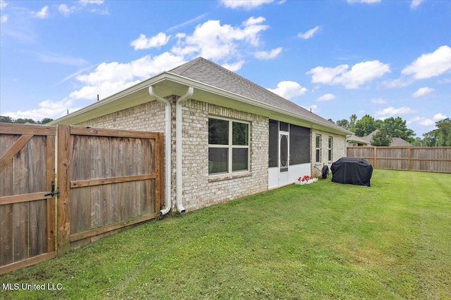 203 Vision Cv, Canton, MS 39046 - back of property featuring a fenced backyard, brick siding, and roof with shingles