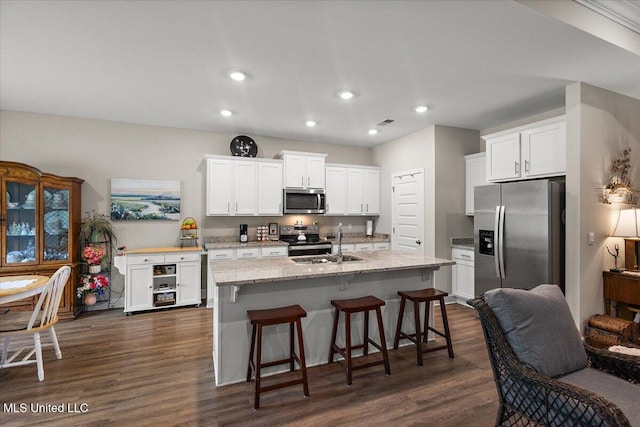 203 Vision Cv, Canton, MS 39046 - kitchen with stainless steel appliances, dark wood finished floors, white cabinets, recessed lighting, and a kitchen bar