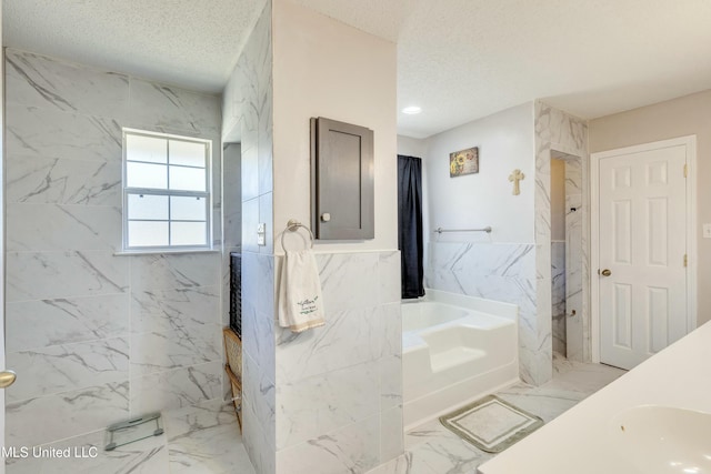 bathroom featuring a textured ceiling, tile walls, independent shower and bath, and sink