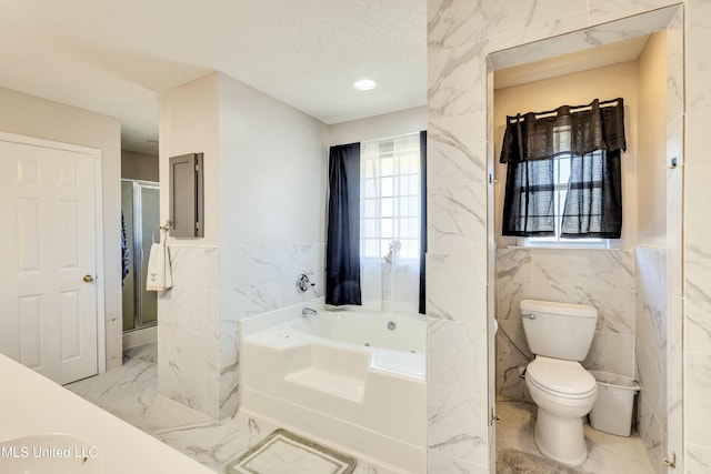 bathroom featuring a textured ceiling, separate shower and tub, tile walls, and toilet