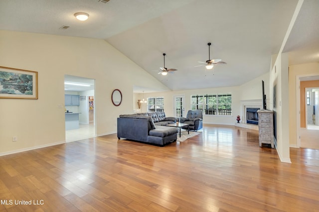 living room featuring high vaulted ceiling, light hardwood / wood-style flooring, and ceiling fan