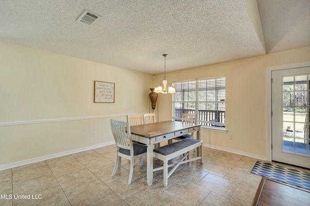 dining room with a notable chandelier, light tile patterned floors, a textured ceiling, and a wealth of natural light