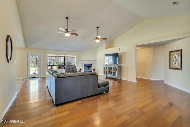 living room with ceiling fan, light hardwood / wood-style flooring, and high vaulted ceiling