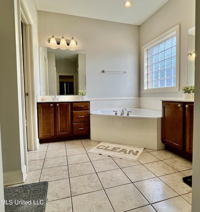 bathroom with tile patterned floors, vanity, and a bathing tub