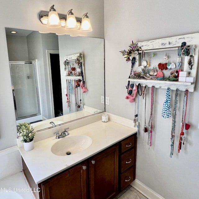 bathroom featuring walk in shower, vanity, and tile patterned flooring