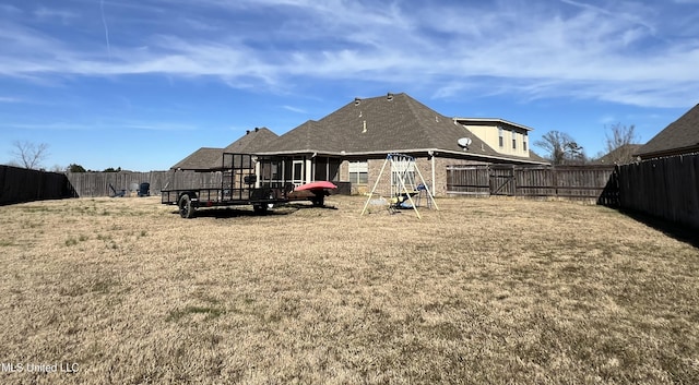 rear view of house with a playground and a yard