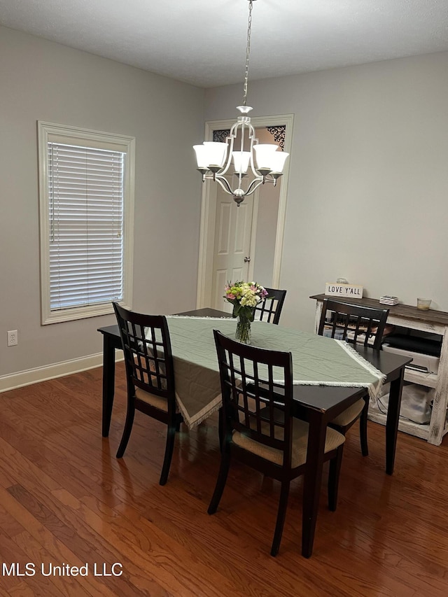 dining area with dark hardwood / wood-style flooring and a chandelier