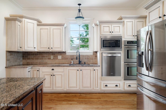 4050 Robinson Xing, Olive Branch, MS 38654 - kitchen featuring appliances with stainless steel finishes, a sink, hanging light fixtures, tasteful backsplash, and light stone counters