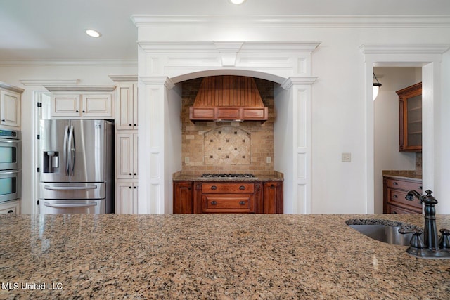 4050 Robinson Xing, Olive Branch, MS 38654 - kitchen featuring stainless steel appliances, premium range hood, light stone countertops, decorative backsplash, and crown molding