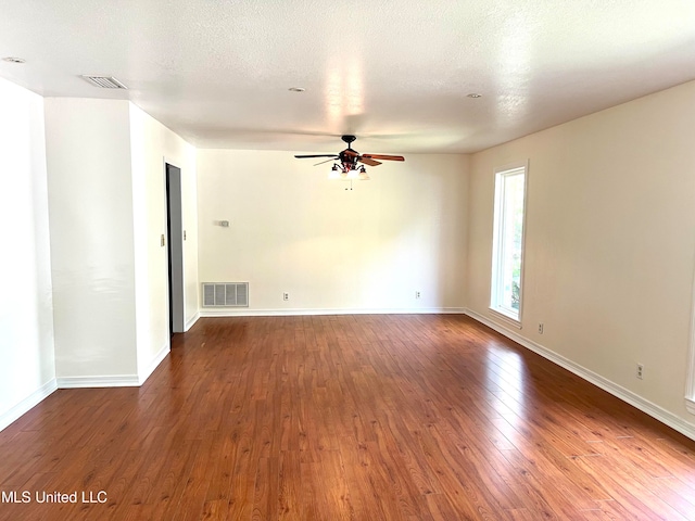 spare room with dark wood-type flooring, ceiling fan, and a textured ceiling