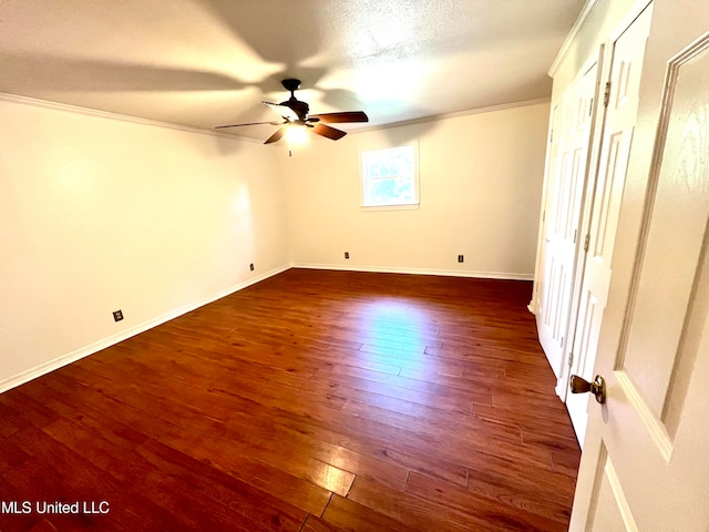 spare room with crown molding, a textured ceiling, dark wood-type flooring, and ceiling fan