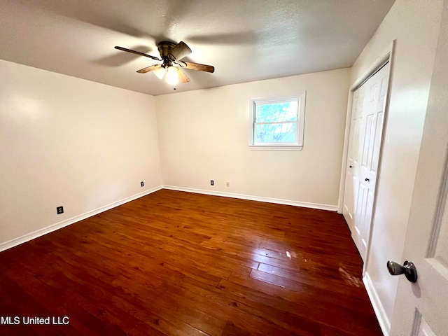 unfurnished bedroom featuring ceiling fan and dark hardwood / wood-style floors