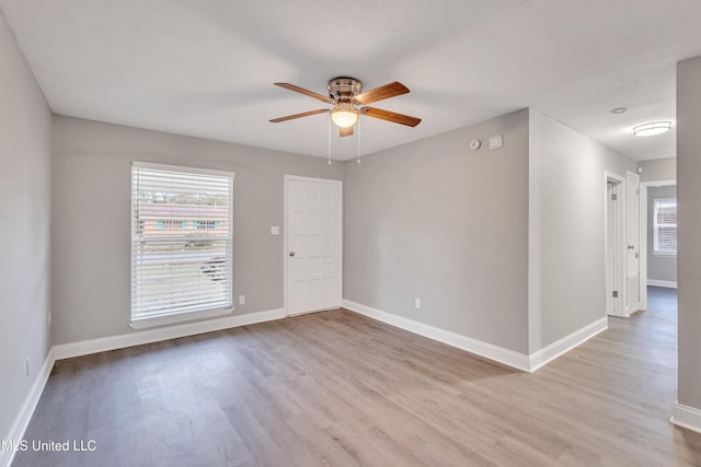 spare room with ceiling fan and light wood-type flooring