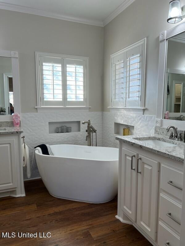 bathroom with wainscoting, wood finished floors, vanity, and crown molding