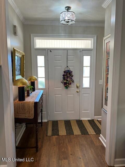 foyer featuring ornamental molding, dark wood-style flooring, and baseboards