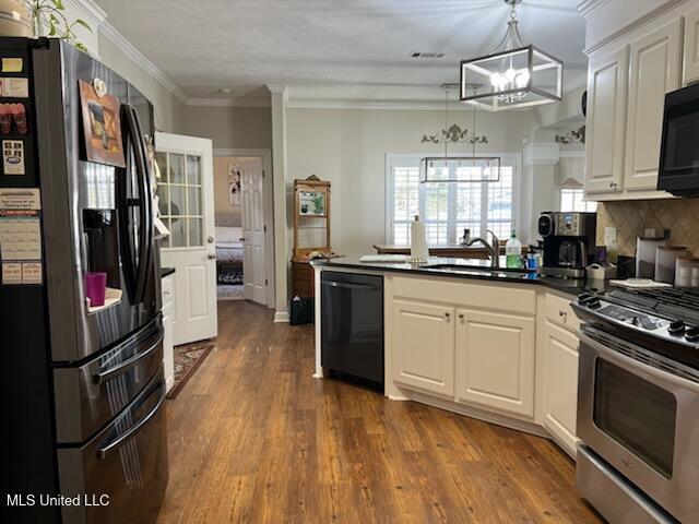 kitchen featuring a peninsula, a sink, white cabinetry, black appliances, and dark countertops