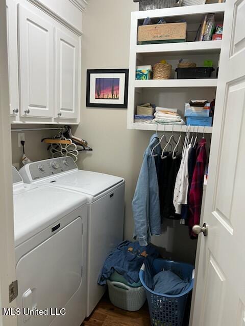 washroom featuring wood finished floors, cabinet space, and washer and dryer