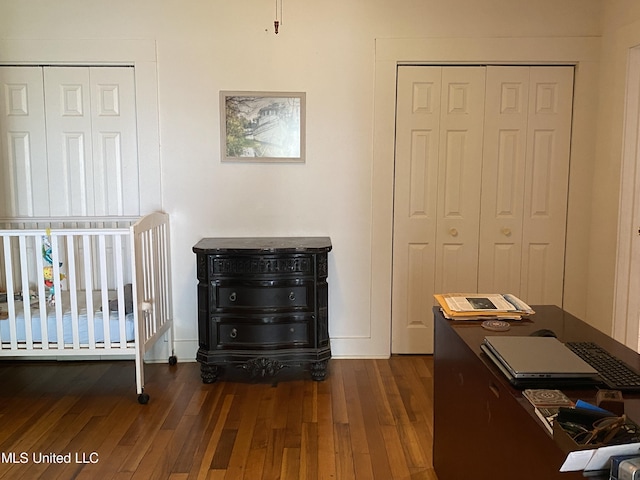 bedroom with wood-type flooring, a closet, and baseboards