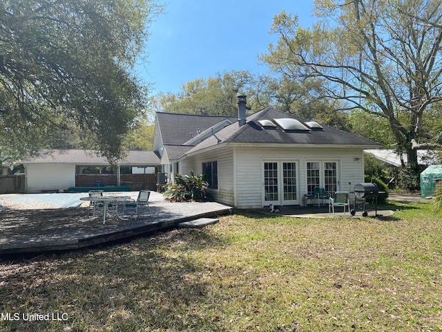 back of property with a wooden deck, a yard, and a patio area