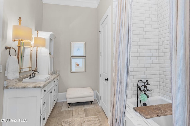 bathroom featuring vanity, a bathtub, ornamental molding, and wood-type flooring