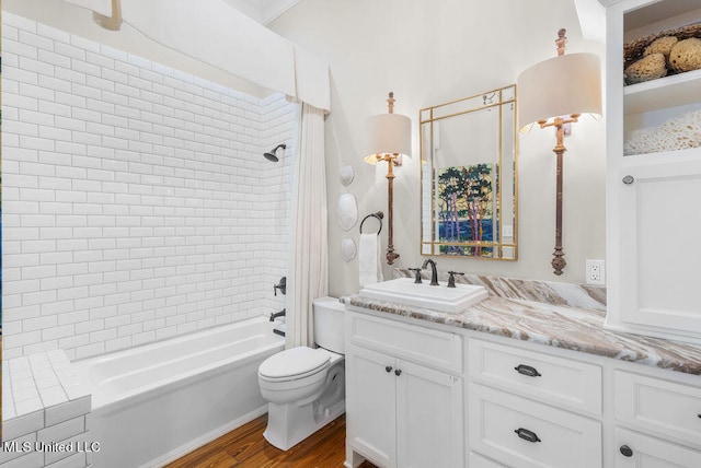 full bathroom with tiled shower / bath, vanity, hardwood / wood-style floors, and toilet