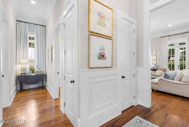 foyer entrance with ornamental molding, dark wood-type flooring, and plenty of natural light