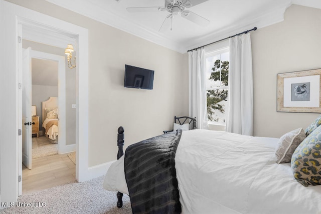 bedroom featuring ceiling fan, crown molding, and light hardwood / wood-style flooring