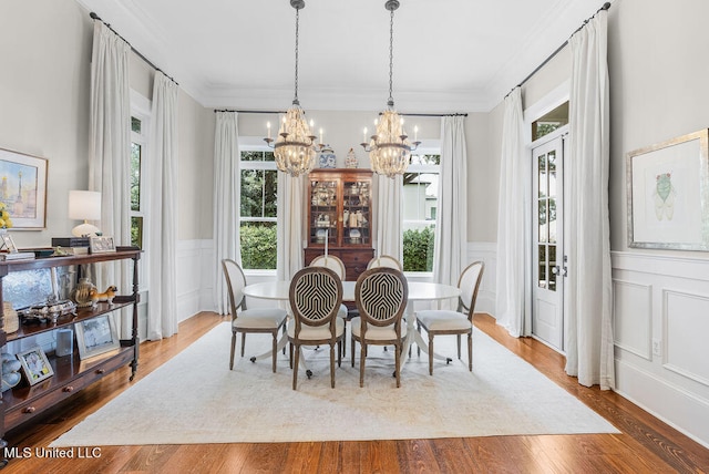 dining area featuring a notable chandelier, ornamental molding, and hardwood / wood-style flooring